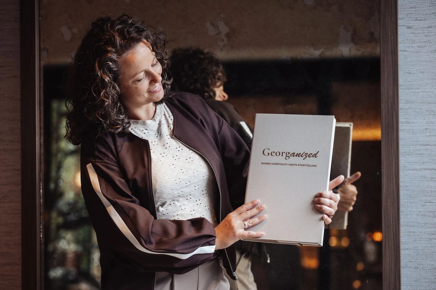 Georget houdt lachend een boek met het Georganized-logo vast